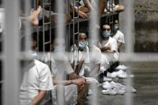 Inmates remain in their cell as Costa Rica's Minister of Security Gerald Campos tours the Centre for Terrorism Confinement (CECOT) during a visit organized by El Salvador's Presidency in Tecoluca, El Salvador, on April 4, 2025. (Photo by Marvin RECINOS / AFP)