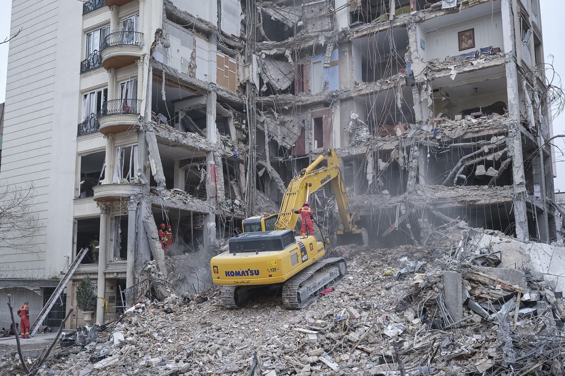 TEHERÁN, 23/03/2026.-Unos trabajadoras desescombran con una excavadora un edificio que fue atacado por Estados Unidos e Israel esta mañana en el barrio de Andarzgu, en el noreste de Teherán. EFE/Jaime León