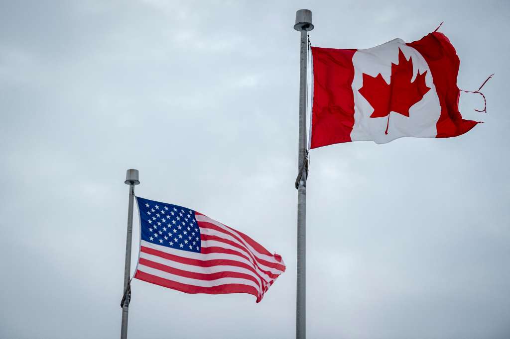 The Canadian and US flags fly near the Canada-US border in Blackpool, Quebec, Canada, on February 2, 2025.