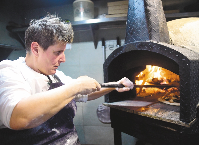 Viviana Varese, chef italiana, horneando una pizza en el restaurante El Casual.