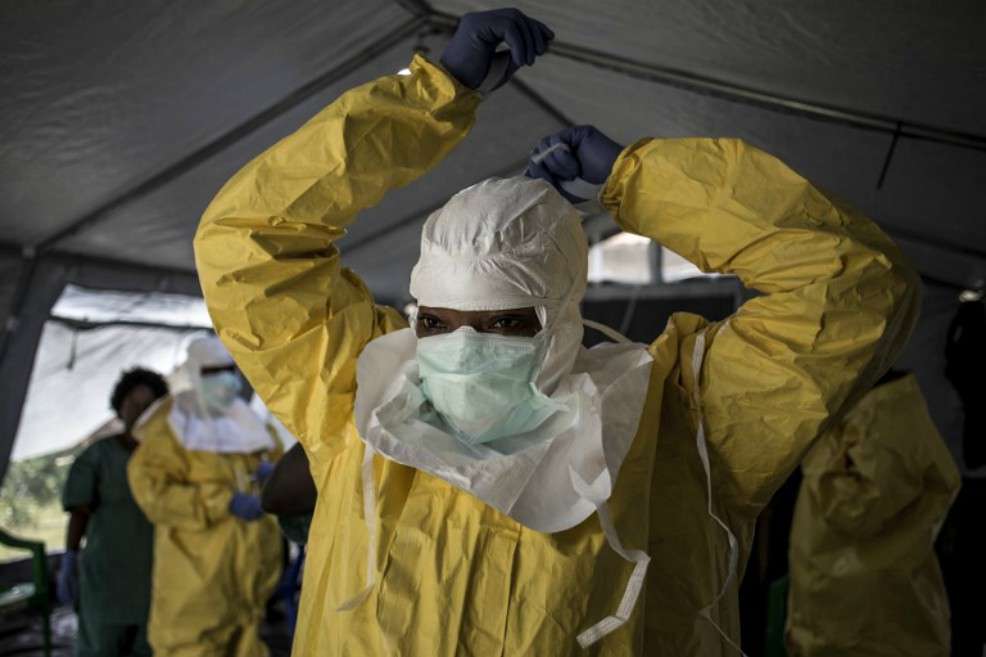Personal médico preparándose para entrar a un centro de tratamiento. / AFP