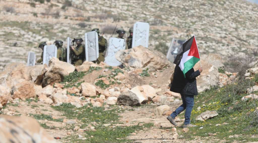 Nablus (-), 24/02/2023.- a Palestinian waves a Palestine flag during clashes with Israeli soldiers after a protest at Bet Dajan village near the West Bank city of Nablus, 24 February 2023. Palestinians protested in the West Bank and Gaza against an Israeli army operation in Nablus on 22 February 2023, which left 11 Palestinians dead and more than 100 injured, some of whom remain in critical condition. (Protestas) EFE/EPA/ALAA BADARNEH