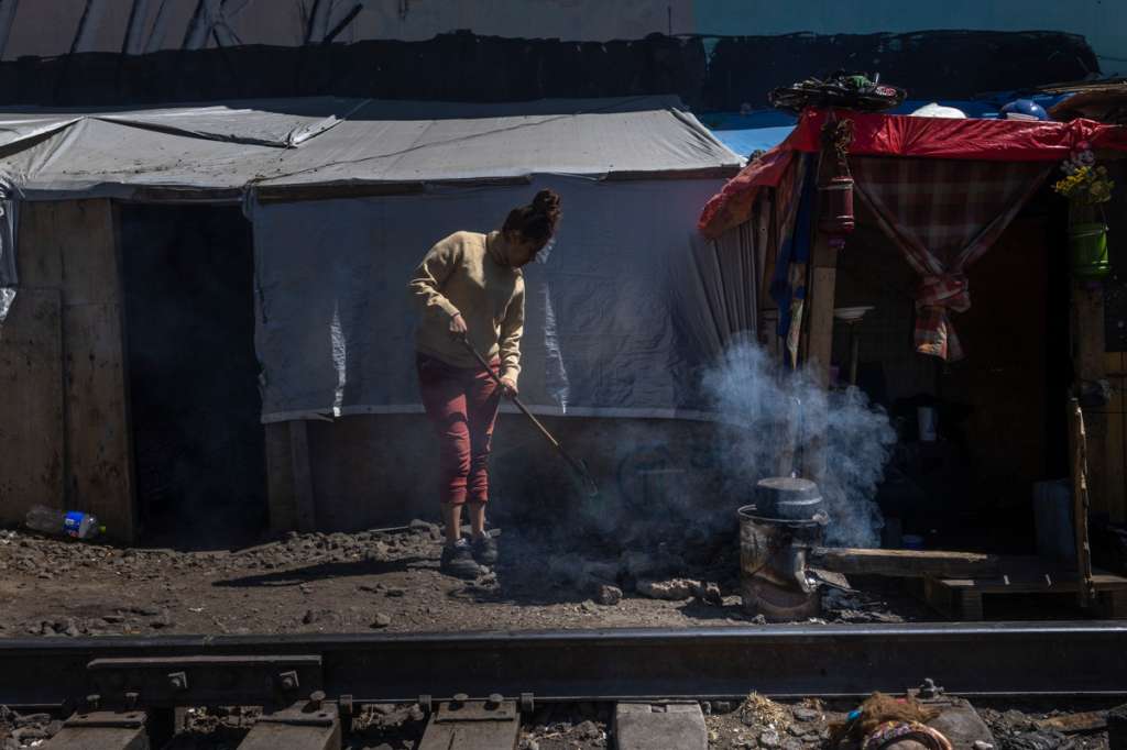 Carmen limpia el exterior de su “ranchito” en el barrio de Vallejo, el lugar que ha sido su hogar durante los últimos meses luego de que ya no pudiera continuar su viaje a Estados Unidos en busca de una vida con más oportunidades y seguridad para ella y su familia.