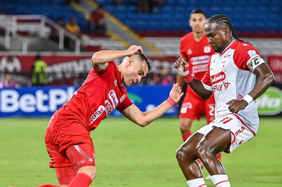 Franco Leys (América) disputa un balón con Hugo Rodallega, capitán de Independiente Santa Fe.