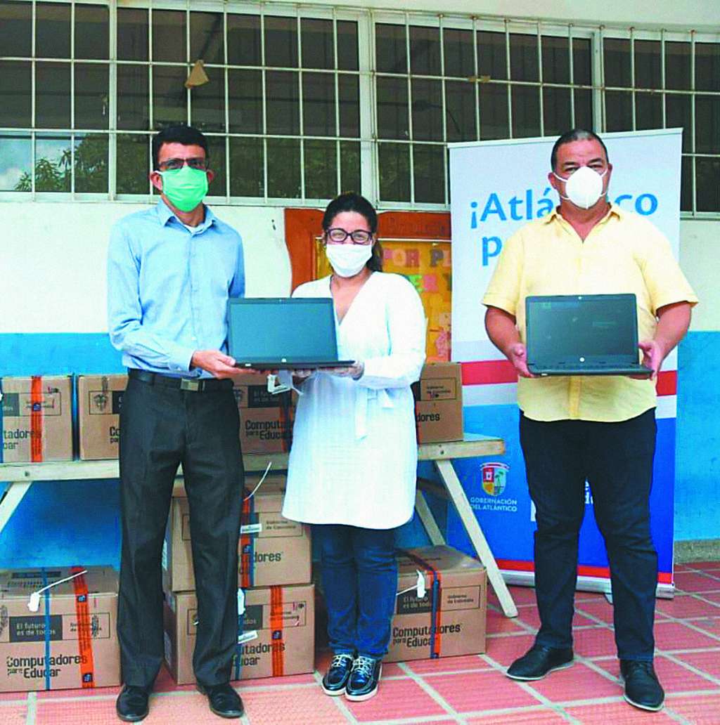 Miembros del Ministerio de Educación entregando algunos de los más de 83.000 computadores en el país.