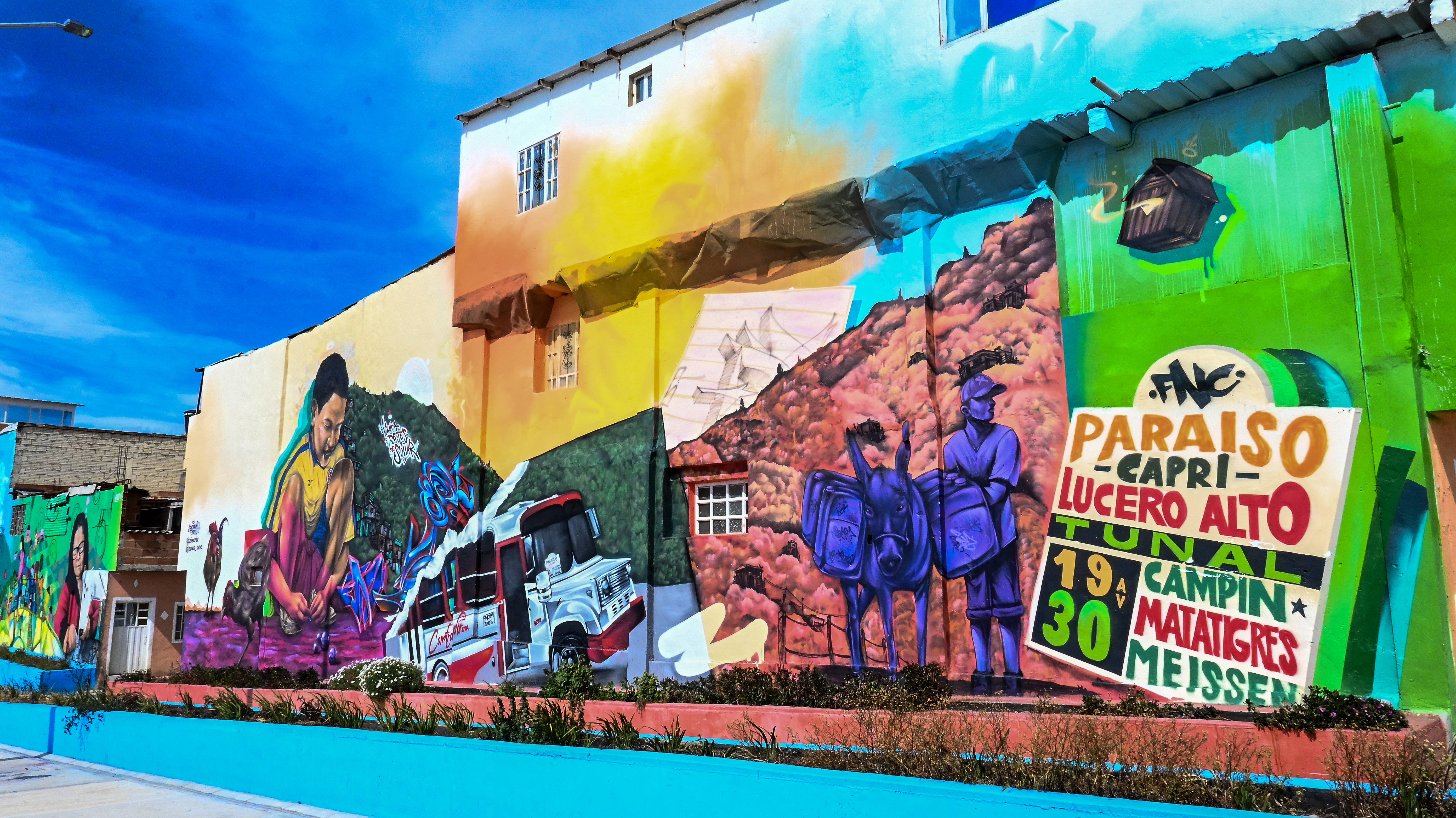 Localidad Ciudad Bolívar
Paseo Alameda Illimani en El Paraíso
El Paseo Alameda Illimaní es un corredor que se extiende a lo largo de 305 metros de longitud y que abarca un área de más de 6.000 m2 entre espacio público. Está adornado con murales coloridos que narran las historias de la comunidad de Ciudad Bolívar y un punto importante de reactivación económica y referente del turismo comunitario.