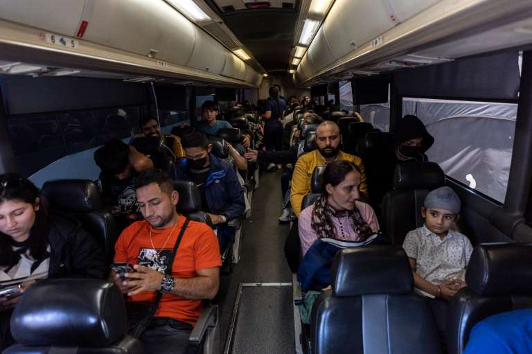 Somerton (United States), 12/05/2023.- Migrants wait in a bus for its departure to the Phoenix Airport from a migrant transition center after being released by Border Patrol, at the Regional Center for Border Health, in Somerton, Arizona, USA, 12 May 2023. A significant increase in the number of migrants crossing was expected as the Covid-era Title 42 policy, which allowed for a quick expulsion of illegal immigrants, expired at 23:59 ET on 11 May. (Estados Unidos, Fénix) EFE/EPA/ETIENNE LAURENT