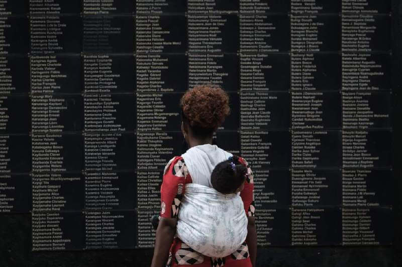Una mujer lee los nombres de las cerca de 800.000 víctimas del genocidio en Ruanda, hace 25 años. / AFP