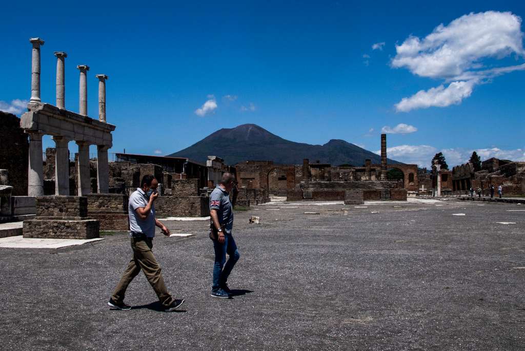(FILES) People walks across the archeological site of Pompeii at the bottom of Mount Vesuvius volcano (Rear) on May 26, 2020, as the country eases its lockdown aimed at curbing the spread of the COVID-19 infection, caused by the novel coronavirus.