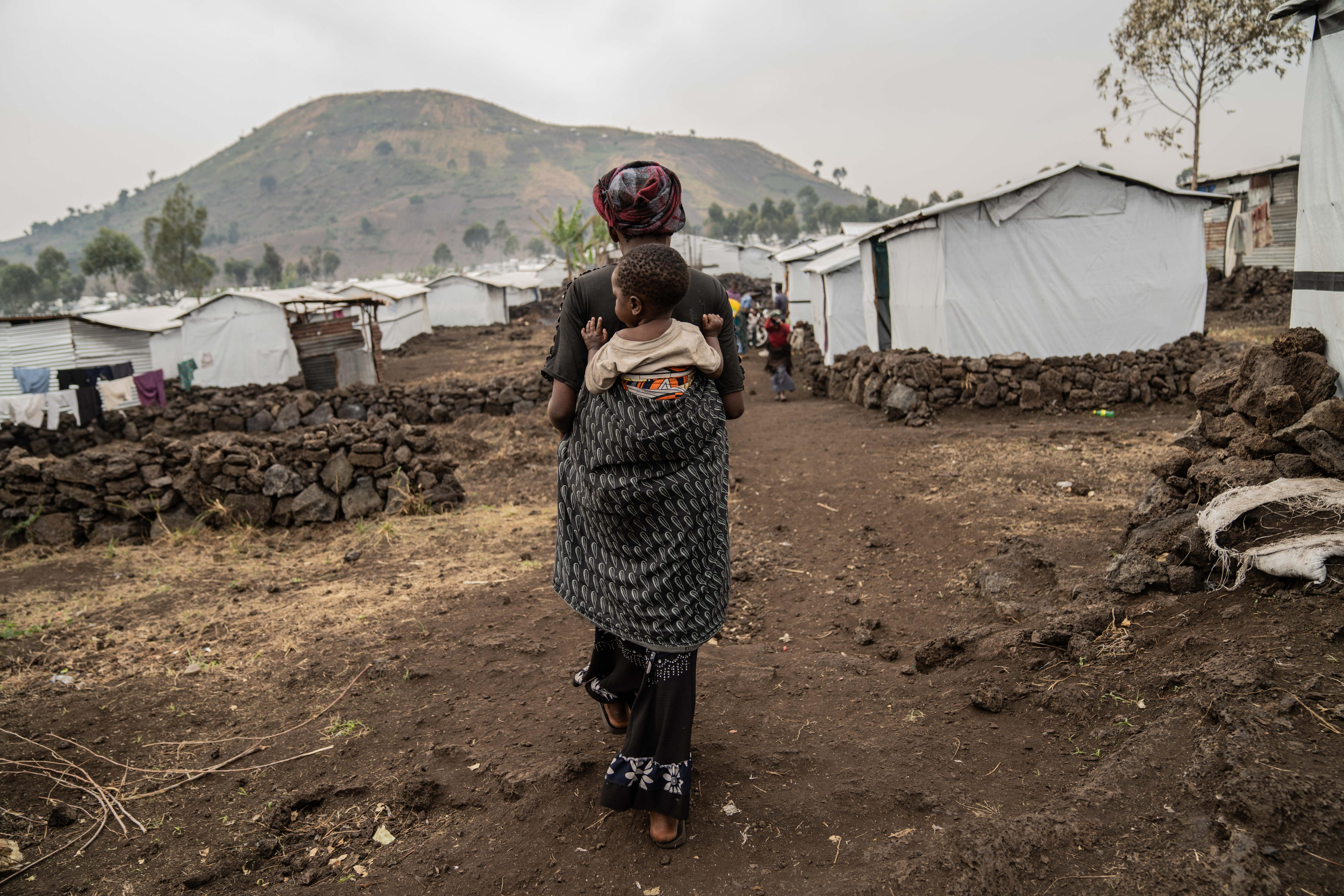 Mudja (Democratic Republic Of Congo), 20/08/2024.- Tuliza Bisere carries her daughter Ishara who was cured of mpox but still shows scars of the disease in the camp for internal displaced persons in Mudja, Democratic Republic of Congo, 20 August 2024. Democratic Republic of Congo'Äôs Health Minister Samuel-Boger Kamba said the death toll due to the mpox outbreak now stands at 'a little more than 570 deaths.' The World Health Organization has declared the rise in mpox cases in the Democratic Republic of the Congo and neighboring countries a public health emergency, with over 27,000 cases and more than 1,100 deaths reported since January 2023. Symptoms include fever, body aches, and rashes, and while there is no specific treatment for mpox, supportive care can aid recovery. The virus spreads through close contact with infected individuals and can persist on contaminated surfaces. EFE/EPA/MOISE KASEREKA