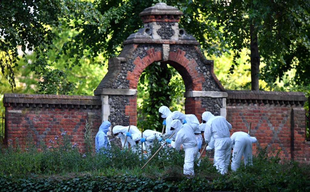 Los oficiales forenses de la policía vestidos con trajes de protección personal de Tyvek (equipo de protección personal) y con máscaras, realizan una búsqueda fuera de una entrada al parque Forbury Gardens en Reading, al oeste de Londres / AFP