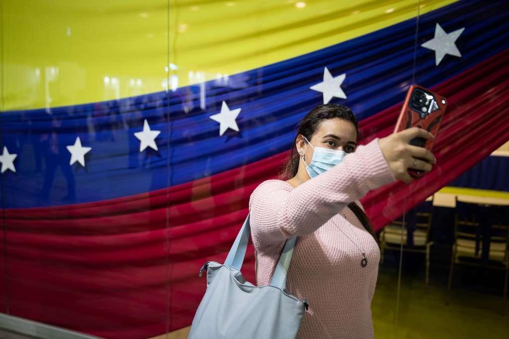 -FOTODELDÍA- AME7674. CARACAS (VENEZUELA), 16/09/2022.- Una mujer se fotografía con la bandera de Venezuela durante la "Expoferia Científico Tecnológica Industrial" de Irán y Venezuela hoy, en el Poliedro de Caracas (Venezuela). EFE/ Rayner Peña R.