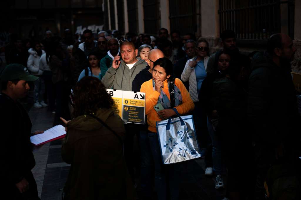 VALENCIA, 16/04/2026.- Un gran número de personas guarda cola ante el padrón municipal de Valencia cuando el plazo para solicitar la regularización extraordinaria de migrantes empieza este jueves para todas aquellas solicitudes en formato 'online', al tiempo que ya es posible pedir cita previa para hacer el trámite de forma presencial. Para demostrar el tiempo que la persona lleva en España se podrá recurrir al padrón municipal pero también a otro tipo de medios como un informe médico, un contrato de luz o alquiler o un certificado de envío de dinero. EFE/Biel Aliño
