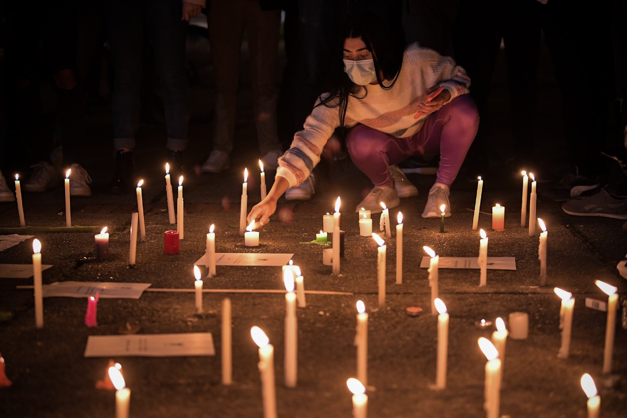 Una mujer prendiendo una vela