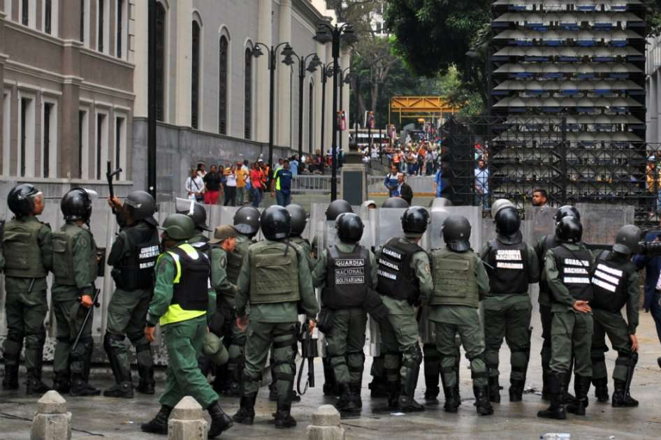 Opositores y oficialistas se enfrentan a un costa de la Asamblea de Venezuela. / AFP