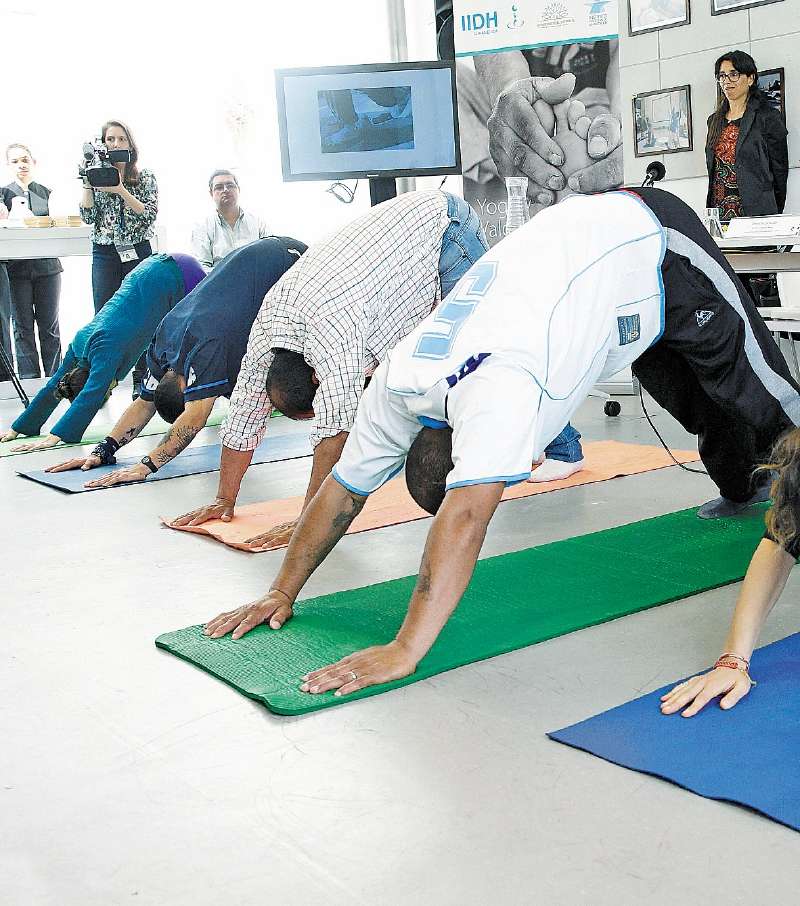 Presos del centro penitenciario de Punta Rieles practicando yoga.   / EFE