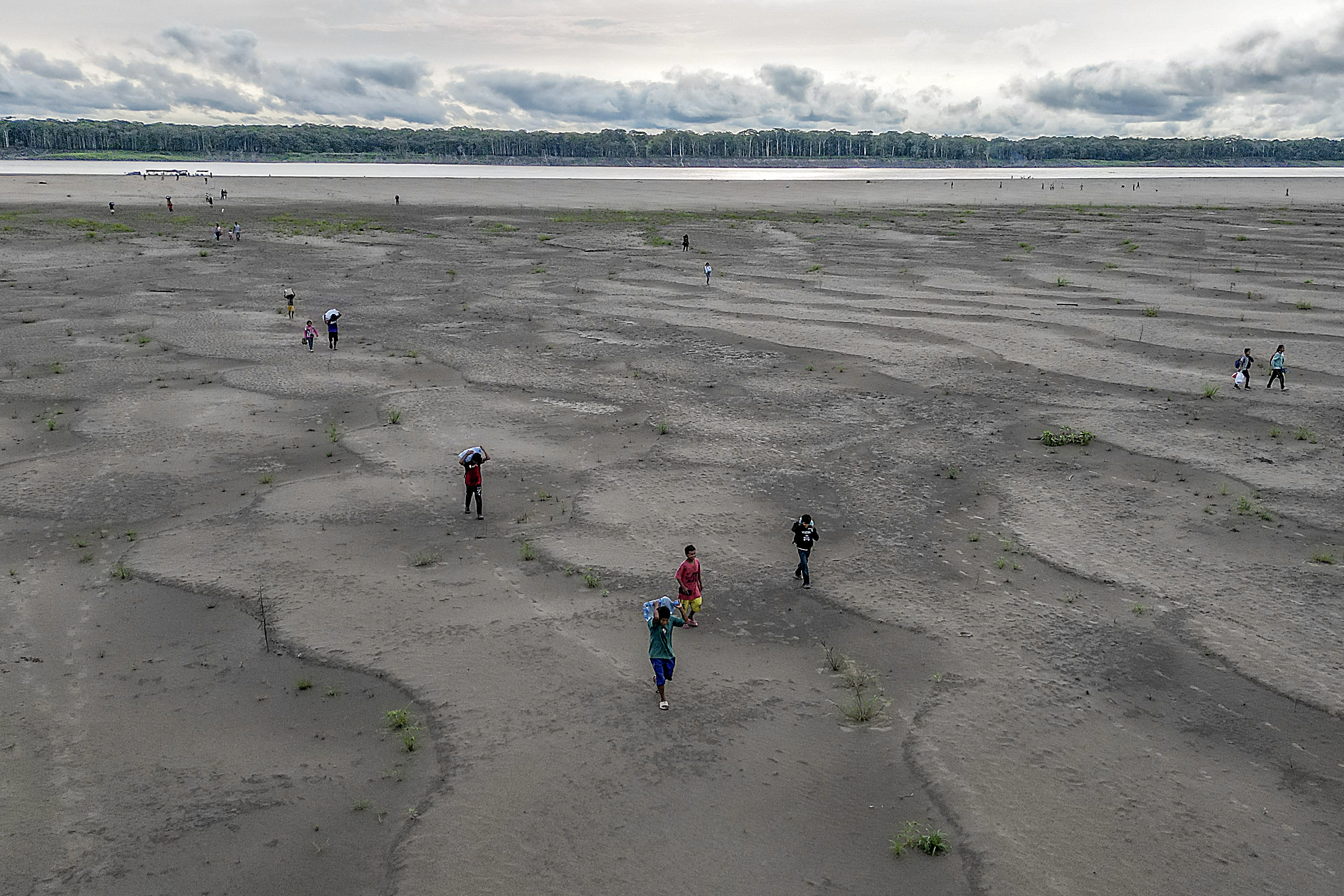 (FILES) Aerial view of Yagua Indigenous people carrying water and other goods due to the low level of the Amazon river at Isla de los Micos, Amazonas department, Colombia, on October 4, 2024.