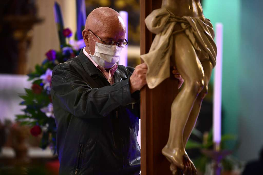 Feligreses asisten con tapabocas a la eucaristía del Viernes Santo en Bogotá, durante la pandemia por Covid-19.