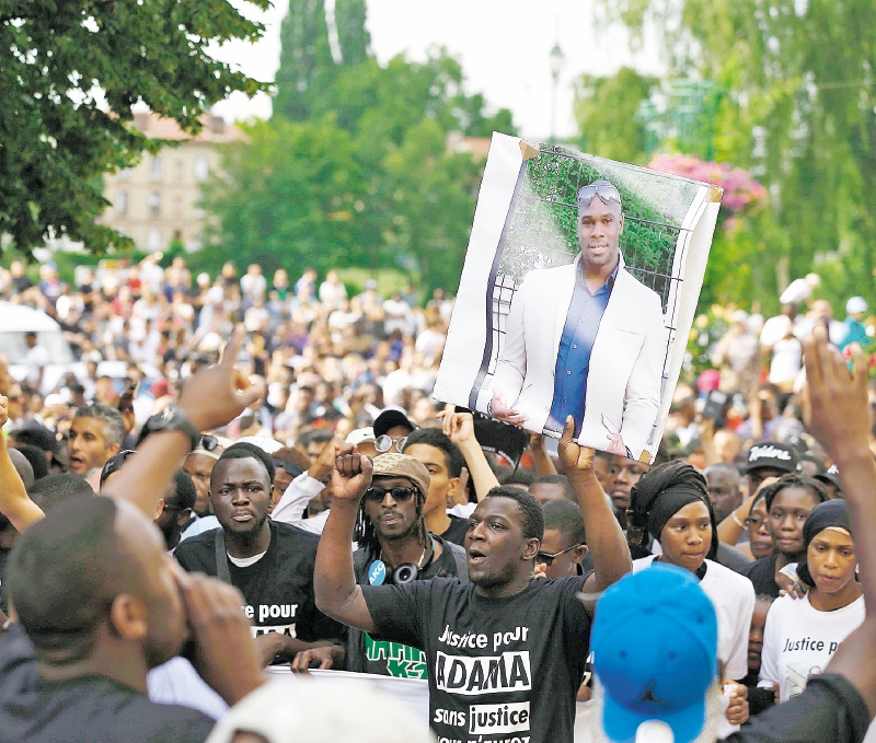 Manifestantes cargan una imagen de Adama Traore, durante una protesta el pasado 22 de julio.  / AFP