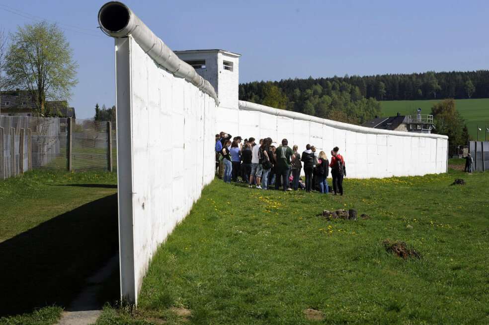 Un grupo de niños de colegio visitan una parte del Muro de Berlín que no fue derribado y que es testigo del histórico momento que cambió el mundo. / AFP