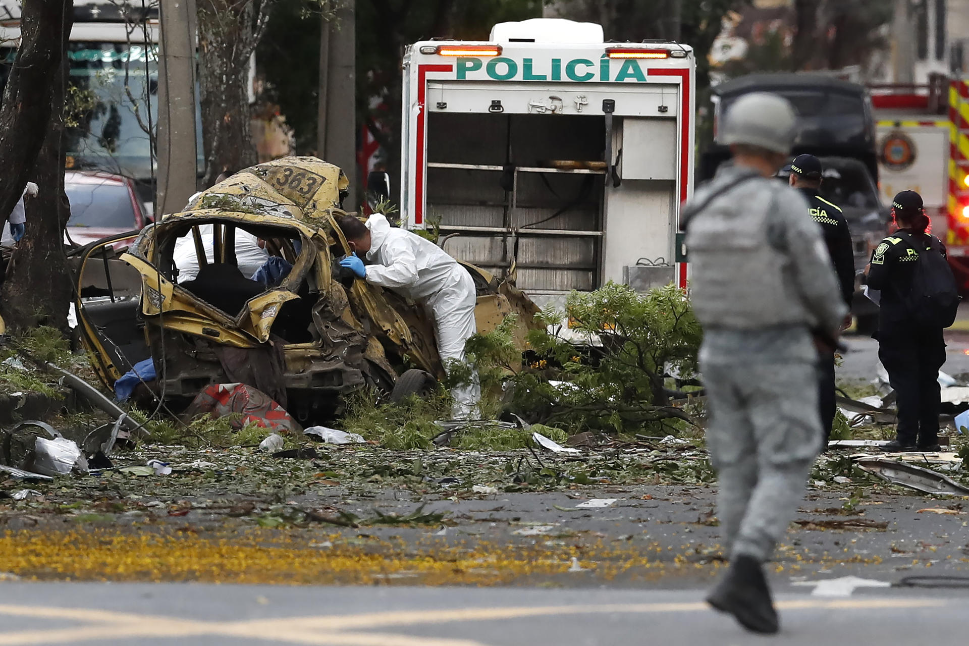 AME2507. CALI (COLOMBIA), 21/08/2025.- Un integrante de la Dirección de Investigación Criminal e Interpol (DIJIN) inspecciona un vehículo afectado tras una explosión en inmediaciones de la Escuela Militar de Aviación Marco Fidel Suárez este jueves, en Cali (Colombia). Al menos cinco personas murieron y 36 resultaron heridas por un atentado perpetrado con un camión bomba. EFE/ Ernesto Guzmán Jr