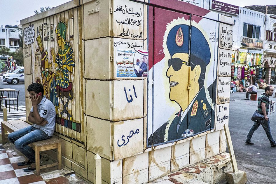Un egipcio sentado junto al grafiti del comandante del ejército y candidato presidencial, Abdel Fatah al Sisi. / AFP