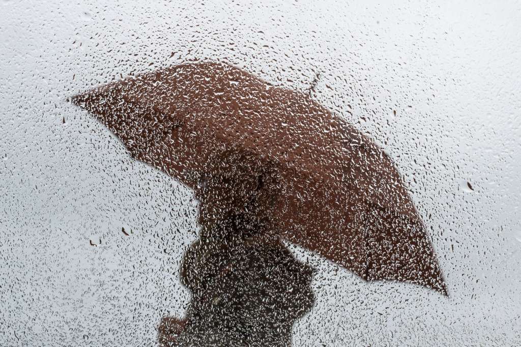 -FOTODELDÍA- SANTANDER, 15/04/2024.- Una persona camina bajo la lluvia, este lunes, junto a la playa de El Sardinero en Santander. EFE/Pedro Puente Hoyos