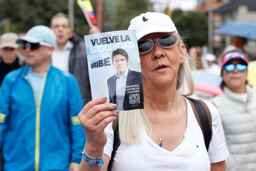 FOTODELDÍA AME4418. BOGOTÁ (COLOMBIA), 08/06/2025.- Una mujer sostiene un cartel durante una caminata por la paz y en apoyo al senador Miguel Uribe Turbay este domingo, en Bogotá (Colombia). La peor expresión de la violencia política colombiana resurgió con el atentado que tiene entre la vida y la muerte al senador y aspirante presidencial de derecha Miguel Uribe Turbay, un ataque que avivó el temor a que el país vuelva a los oscuros años de finales del siglo pasado cuando fueron asesinados varios candidatos presidenciales. EFE/ Mauricio Dueñas Castañeda