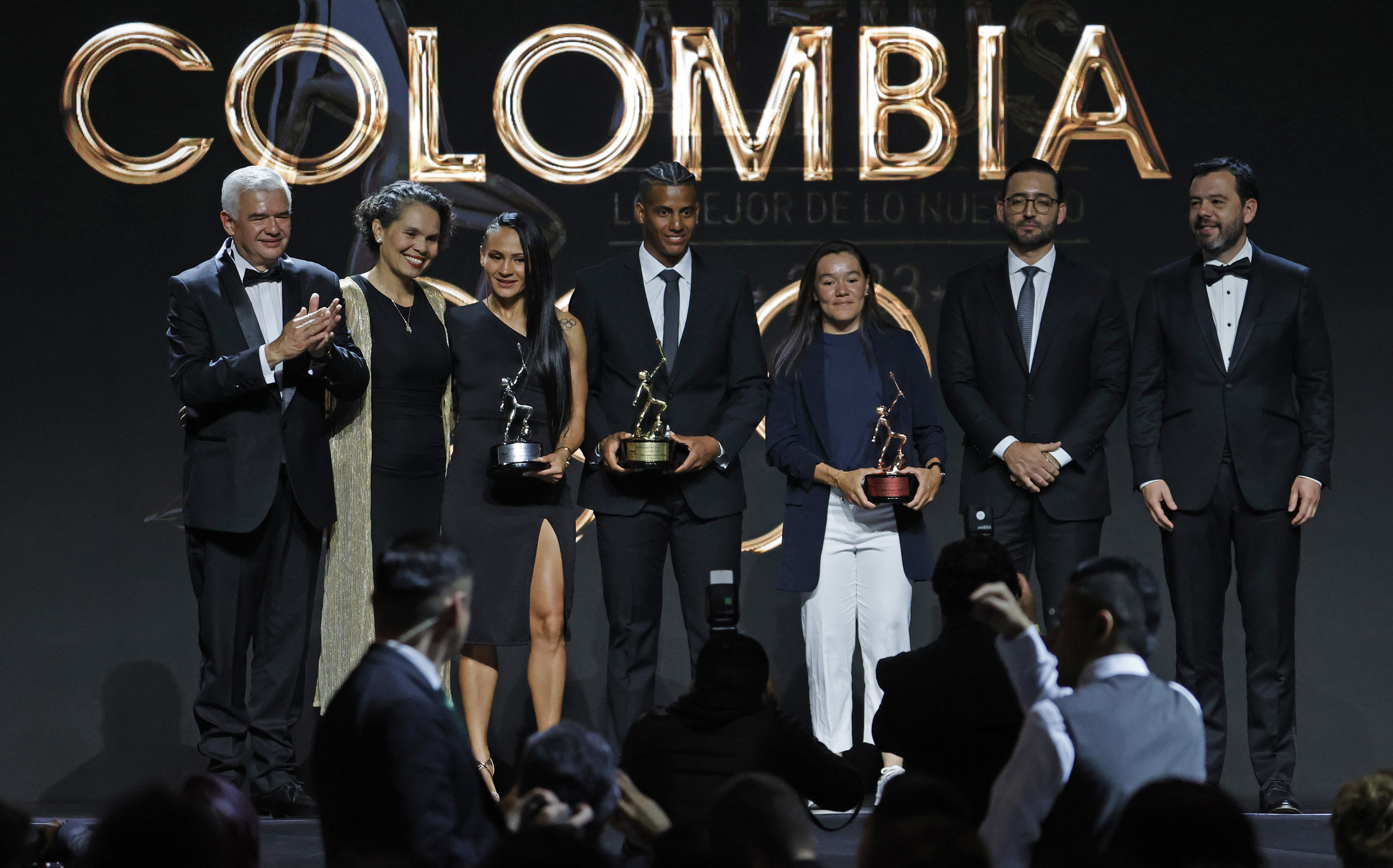 AME795. BOGOTÁ (COLOMBIA), 18/01/2024.- La ministra del deporte, Astrid Rodríguez (2izq.), y el presidente del comité olímpico colombiano, Ciro Solano (1izq.), el alcalde de Bogotá, Carlos Fernando Galán (1der.), son fotografiados junto a los deportistas del Año ganadores en la categoría Élite Yeni Arias (3izq.), boxeo; Kevin Santiago Quintero (c), ciclismo de pista; Marta Bayona (3der.), ciclismo de pista durante los Premios Altius 2023, organizados por el Comité Olímpico Colombiano (COC), hoy en Bogotá (Colombia). El campeón mundial del keirin, Kevin Santiago Quintero, recibió este jueves el premio Altius de Oro concedido por el Comité Olímpico Colombiano (COC) al mejor deportista de 2023, en una gala realizada en Bogotá. En agosto pasado el ciclista conquistó el título del keirin y la camiseta arcoiris que lo acredita como campeón mundial de esta especialidad en pista, tras ganar la final en el Velódromo Sir Chris Hoy de Glasgow, en los Campeonatos Mundiales de Ciclismo 2023. EFE/ Mauricio Dueñas Castañeda