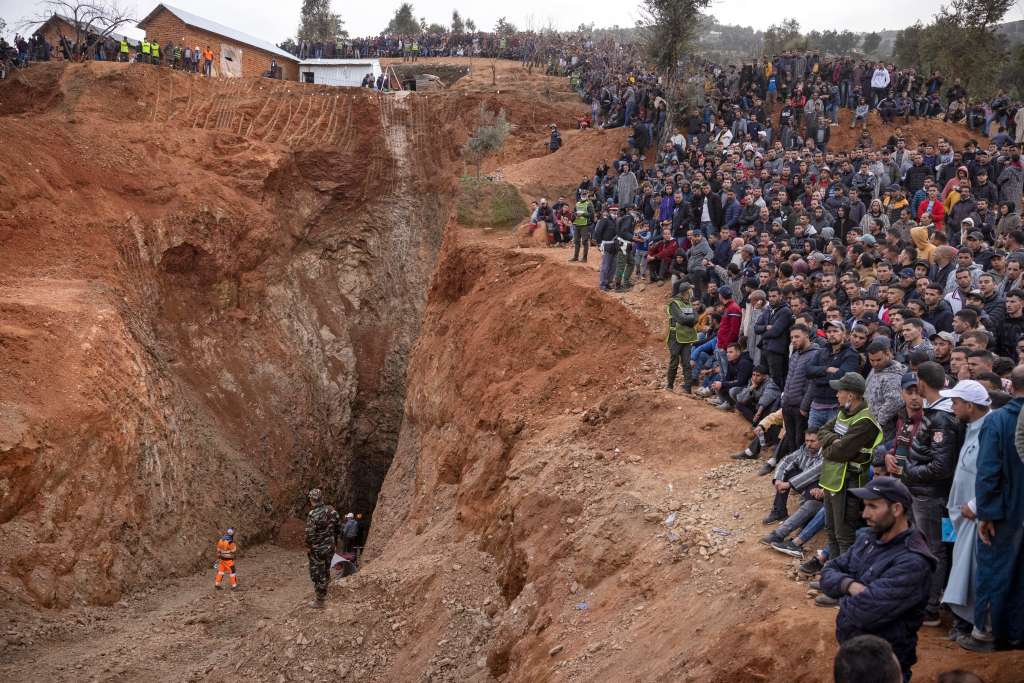 Los transeúntes observan cómo los equipos de emergencia marroquíes trabajan para rescatar a Rayan, un niño de cinco años, que cayó en un poso el 1 de febrero, en la remota aldea de Ighrane, en la provincia rural del norte de Chefchaouen.