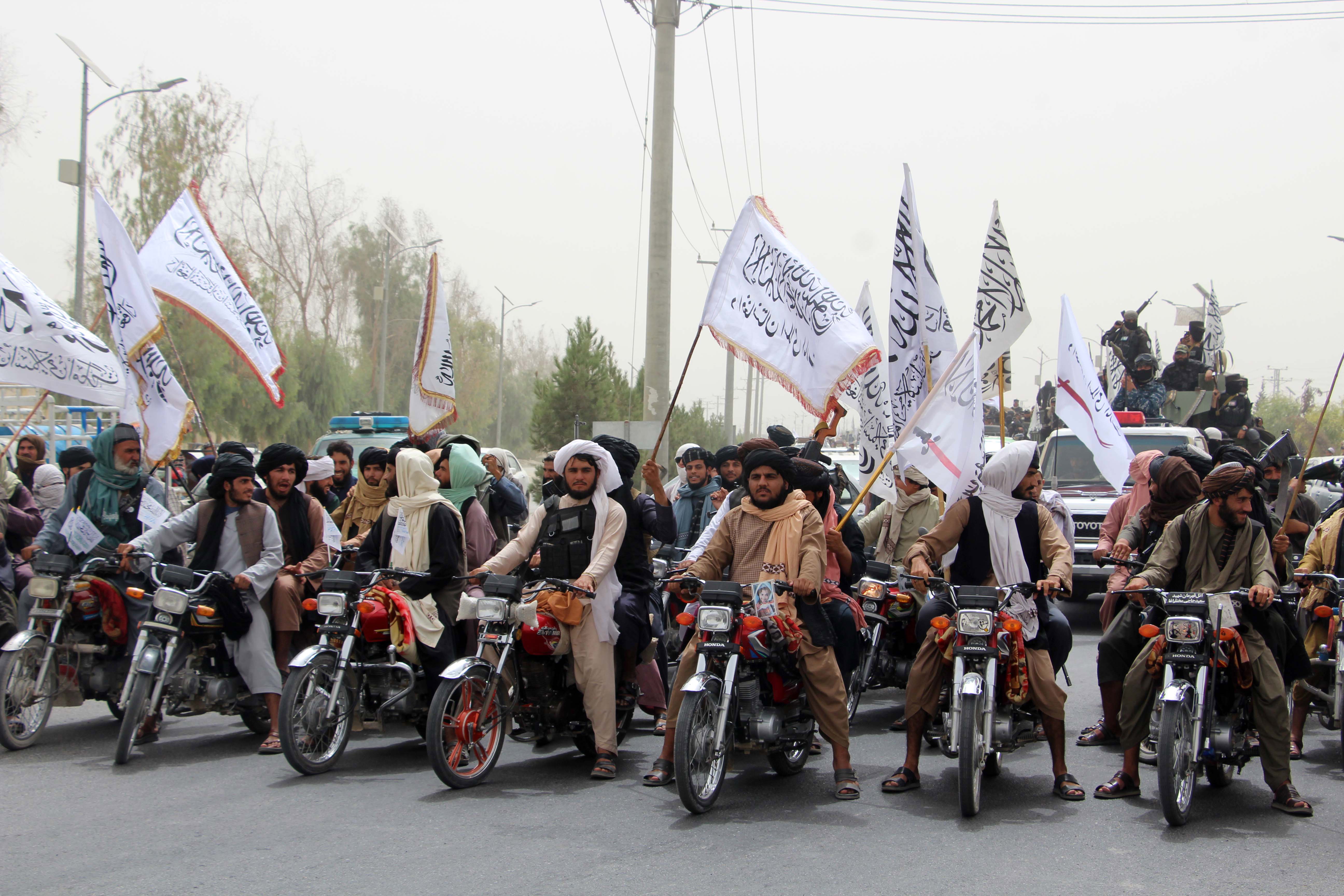 Kandahar (Afghanistan), 15/08/2023.- Afghans hold flags of Islamic Emirate of Afghanistan, as they celebrate second anniversary of Taliban taking over the government, in Kandahar, Afghanistan, 15 August 2023. The Taliban's ascent to power on 15 August 2021 has led to the extremist interpretation of Shariah or Islamic law, resulting in a complete reversal of the women's rights ensured in recent years. Meanwhile, the takeover has led to the country being isolated internationally, after the international community turned back on the new Taliban government and imposed sanctions whose burden is being borne by common Afghans. (Afganistán) EFE/EPA/STR