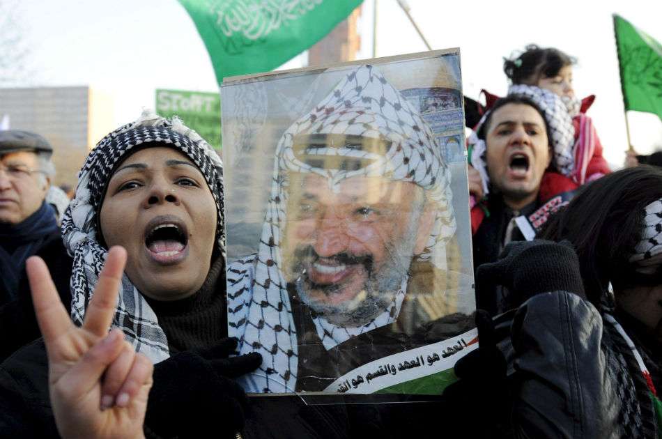 Una mujer sostiene una fotografía del fallecido líder palestino Yasir Arafat durante una manifestación contra la ofensiva israelí sobre Gaza en Berlín, Alemania en enero de 2009