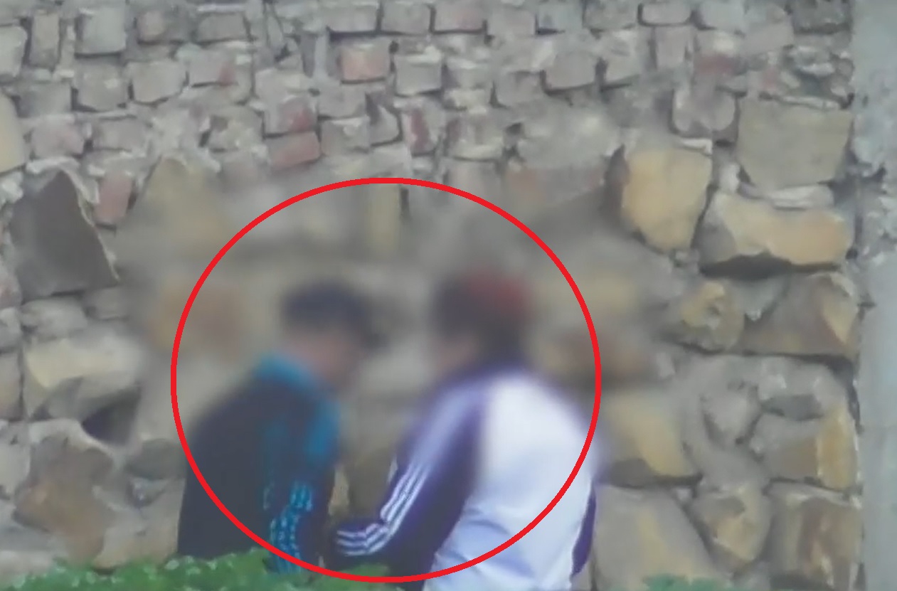 De acuerdo con las autoridades, en esta toma se puede ver cómo uno de los líderes de la red le enseña a una mujer a "encaletar" las dosis de droga, en el muro que se ve en la parte de atrás.