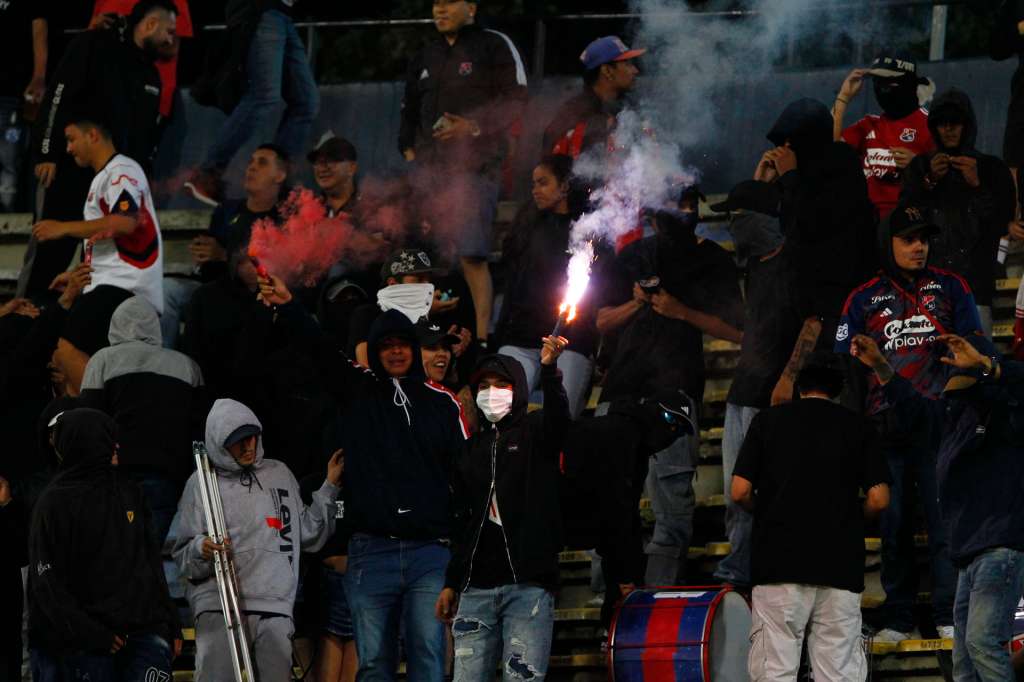AMDEP5050. MEDELLÍN (COLOMBIA), 07/05/2026.- Aficionados de Medellín prenden bengalas durante una protesta en el partido de la fase de grupos de la Copa Libertadores entre Independiente Medellín y Flamengo este jueves, en el estadio Atanasio Girardot en Medellín (Colombia). Aficionados del club colombiano, que protestan por el mal momento del equipo, eliminado el domingo pasado de la liga local, lanzaron pirotecnia desde la tribuna norte, lo que originó una humareda que causó poca visibilidad en la cancha; arrojaron objetos, e intentaron ingresar al terreno de juego. EFE/ STR