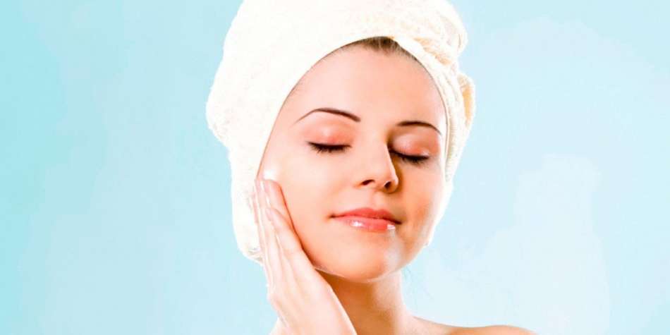 Mujer aplicándose crema en el rostro