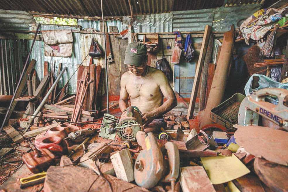 Antonio Dinorio, de la comunidad indígena tikuna, talla madera palo sangre en su taller, ubicado en Leticia (Amazonas). / Andrés Velasco