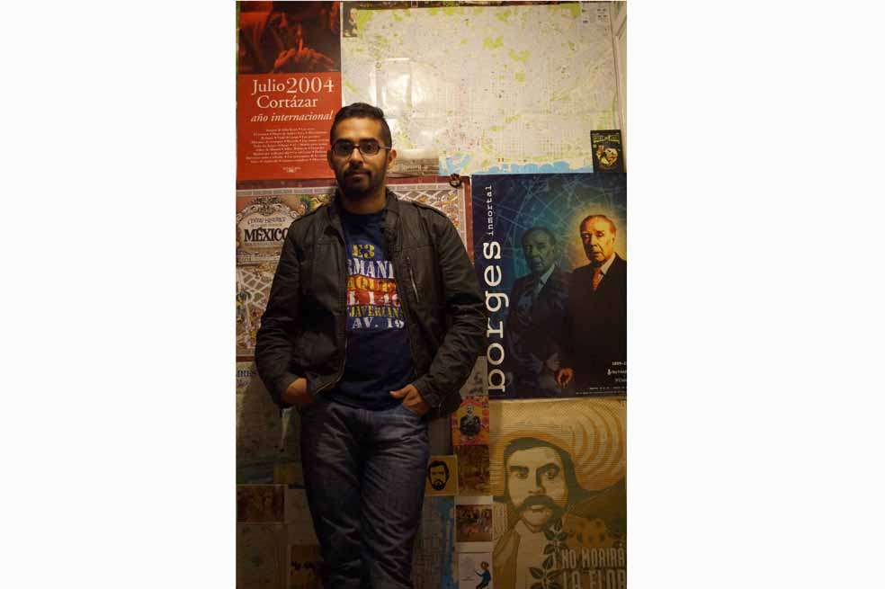 Juan Camilo Rincón desde el lugar que le sirve de inspiración: su casa. Al fondo, imágenes de sus autores preferidos. / Cortesía
