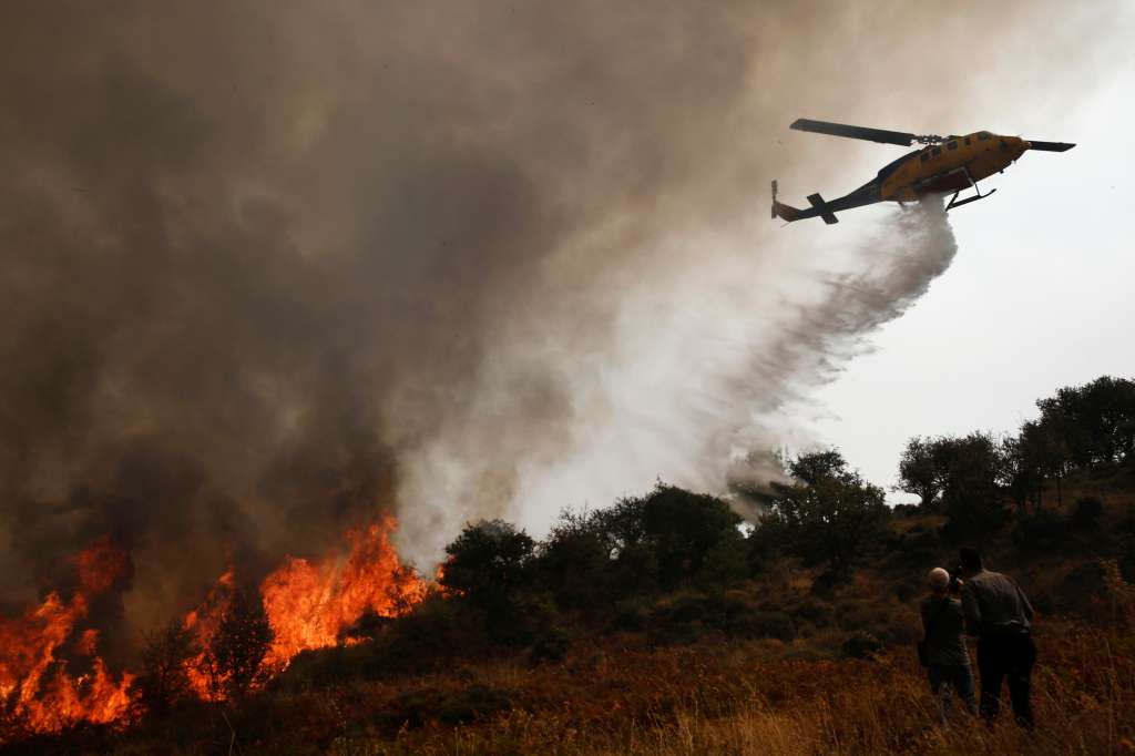 Sofiana (Greece), 01/10/2024.- A firefighting helicopter drops water over a wildfire in the area of Sofiana in Corinthia, Greece, 01 October 2024. The air force has been reinforced in the fight against the fire that broke out on September 29 in a forest area in Rozena Xylokastro, Corinthia, where two people lost their lives. According to the Fire Service, the firefighters are dealing with scattered outbreaks. Strong ground forces remain in the area amid fears of flare-ups. Schools in the area remain closed for a second day. (incendio forestal, Grecia) EFE/EPA/YANNIS KOLESIDIS