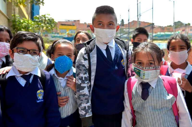 Estudiantes de Soacha, al sur de Bogotá, usando tapabocas para evitar el virus COVID19 hechos de materiales reciclables y biodegradables en protesta contra la escasez en las farmacias. / AFP