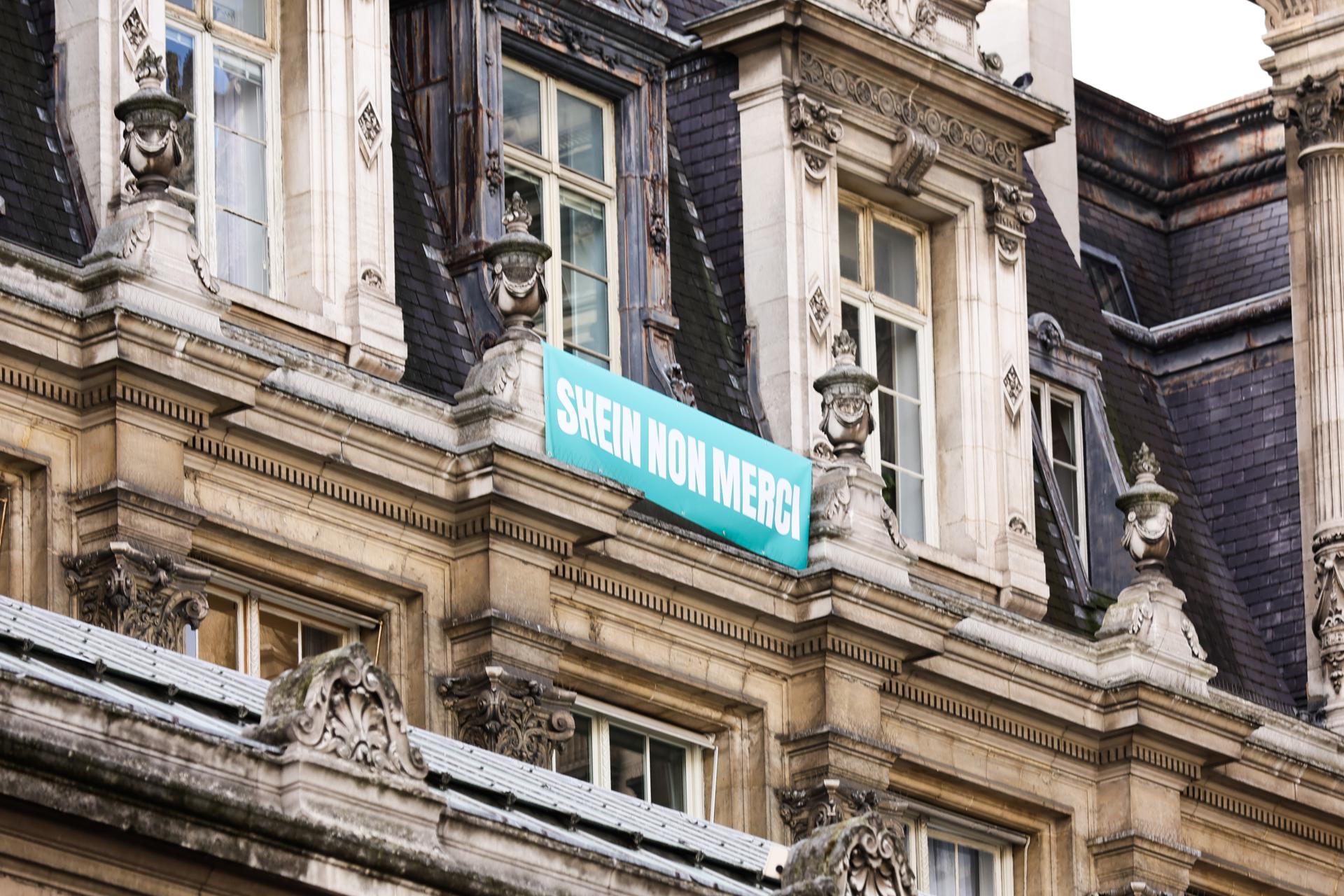 Paris (France), 05/11/2025.- A banner reading “Shein no thanks” hangs at Paris City Hall on the opening day of Shein’s first-ever physical store in Paris, France, 05 November 2025. Shein’s arrival has sparked controversy, with a petition calling for its cancellation gathering 110,000 signatures. In 2025, the company was fined 191 million Euros for cookie law violations, false promotions, misleading information, and failing to disclose microplastics in products. The brand is also facing scandal over dolls with pornographic content sold online. (Francia) EFE/EPA/TERESA SUAREZ