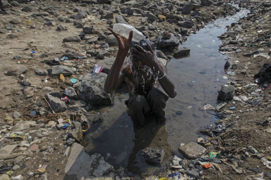 Un indio se refresca con agua en Bombai, India, hoy, martes 22 de abril del 2014. El Día de la Tierra, que se comenzó a celebrar en 1970, se conmemora de manera global, este año bajo la temática "Ciudades Verdes", que anima a los ciudadanos a transformar sus ciudades en un medio más sostenible. EFE/ Divyakant Solanki