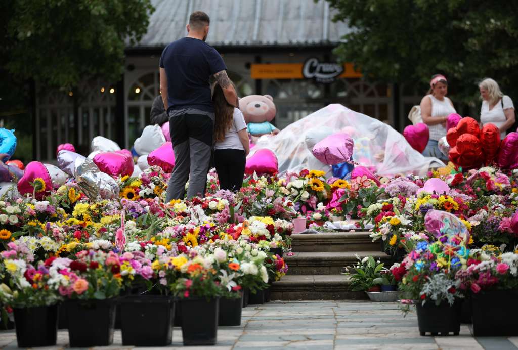 Southport (United Kingdom), 05/08/2024.- People look at tributes during a vigil for the victims of the Southport knife attack in Southport, Britain, 05 August 2024. 17-year-old Axel Rudakubana has been charged with three counts of murder, 10 counts of attempted murder and one count of possessing a bladed article after an attack in Southport which left three children dead and eight more seriously injured, along with two adults. (Reino Unido) EFE/EPA/ADAM VAUGHAN