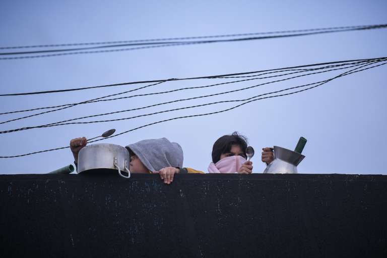 Dos persona en un balcón con ollas