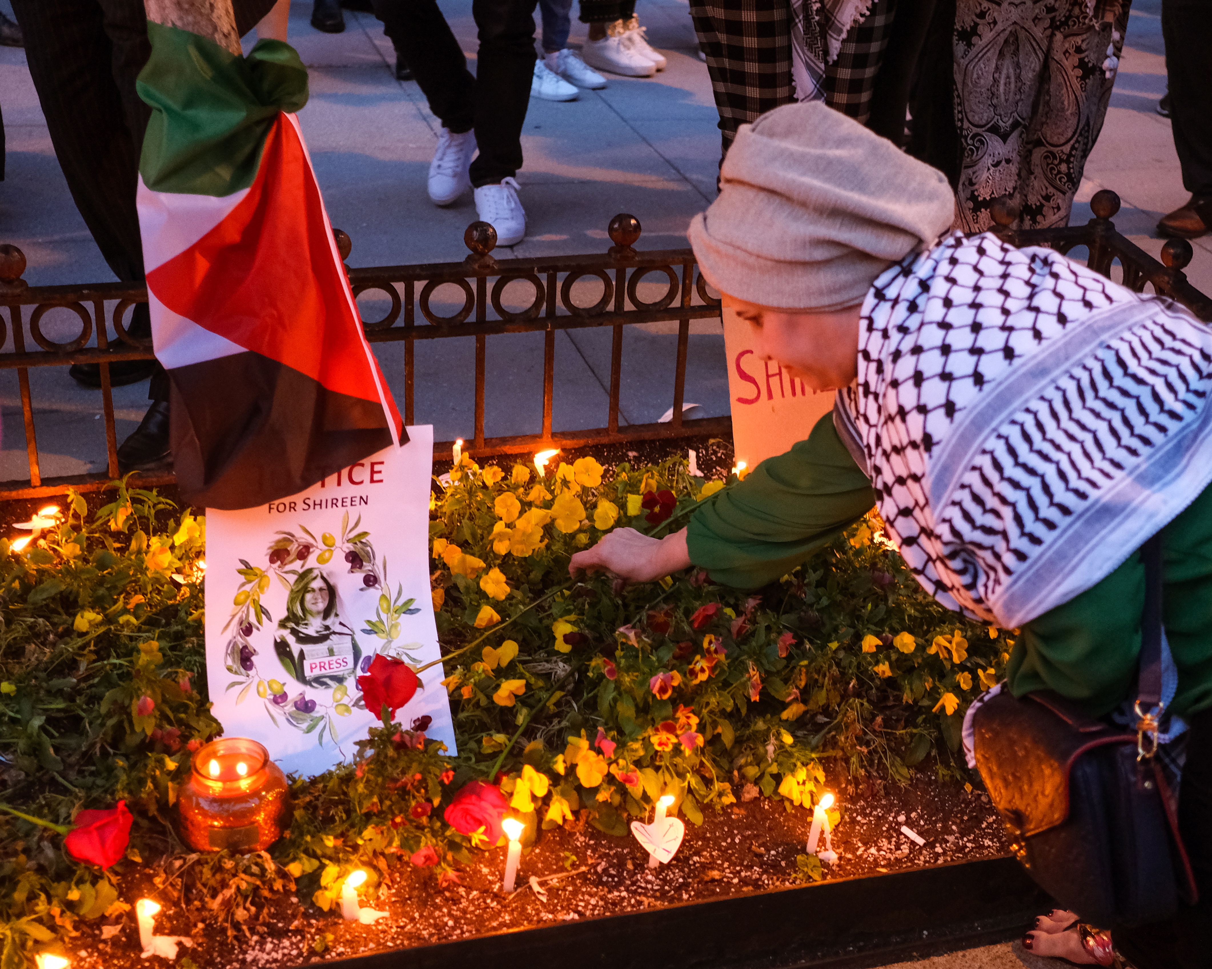 Washington (United States), 17/05/2022.- A woman places a flower on a make-shift memorial during a candlelight vigil to honor the slain al-Jazeera Journalist Shireen Abu Akleh, in Washington, DC, USA, 17 May 2022. Al Jazeera journalist Shireen Abu Akleh was killed on 11 May 2022 during a raid by Israeli forces in the West Bank town of Jenin. (Estados Unidos) EFE/EPA/GAMAL DIAB