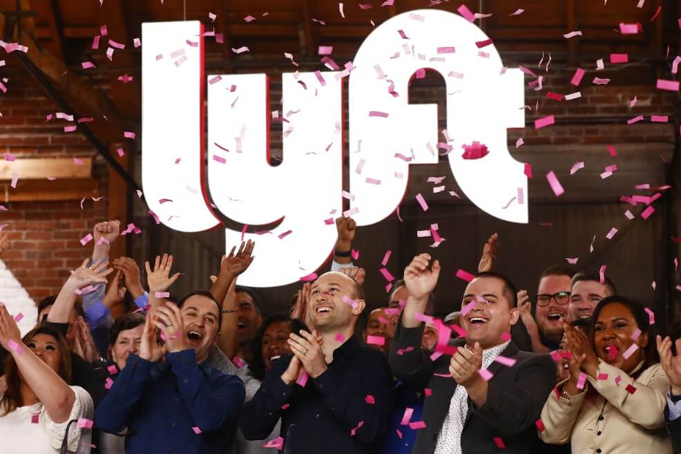 Logan Green (izq.) y John Zimmer (centro), directivos de Lyft, celebran su entrada a la bolsa. / AFP.