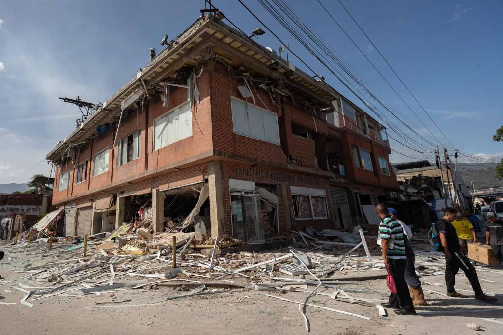 AME4374. CATIA LA MAR (VENEZUELA), 25/06/2026.- Personas observan una casa afectada por terremotos este jueves, en Catia La Mar (Venezuela). El número de fallecidos en Venezuela a causa de los dos terremotos del miércoles se elevó a 188 y el de heridos a 1.520, mientras que al menos 346 construcciones, entre edificios, hospitales y centros comerciales, resultaron afectadas, informó el presidente de la Asamblea Nacional (AN, Parlamento), el chavista Jorge Rodríguez. EFE/ Ronald Peña R.