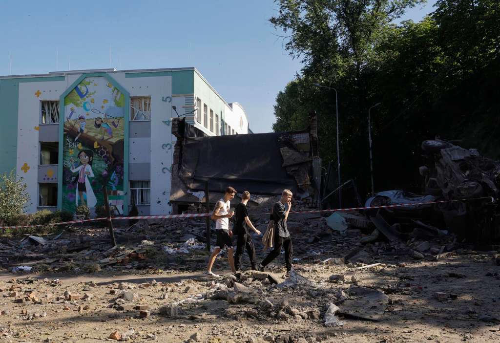 Kyiv (Ukraine), 04/07/2025.- Local people walk in a damaged area with destroyed cars near a school building after a Russian airstrike in Kyiv, Ukraine, 04 July 2025, amid the Russian invasion. More than 20 people were injured after Russian forces launched an overnight large-scale combined attack with at least 11 missiles and 539 drones across Ukraine, with Kyiv as the main target, the State Emergency Service (SES) of Ukraine reported. (Rusia, Ucrania, Kiev) EFE/EPA/SERGEY DOLZHENKO