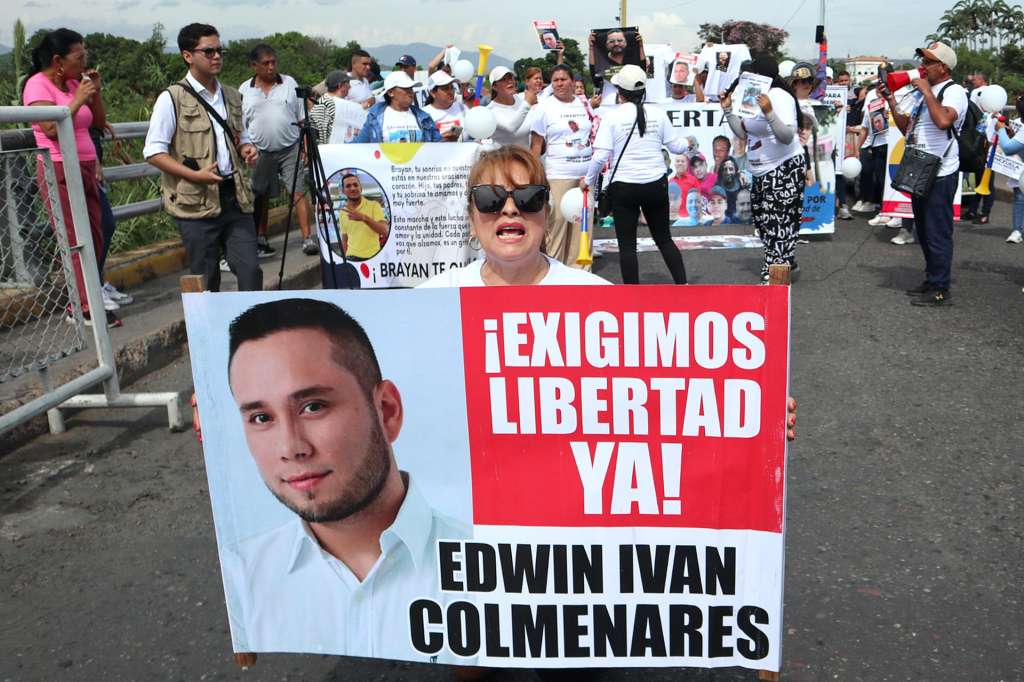 AME7042. LA PARADA (COLOMBIA), 11/10/2025.- Familiares de ciudadanos colombianos detenidos en Venezuela sostienen carteles en una protesta para exigir su libertad este sábado, en el puente internacional Simón Bolívar en La Parada (Colombia). Convocados bajo el lema "¡Libérenlos!", madres, padres, esposas e hijos se reunieron en medio del paso fronterizo con pancartas, fotografías y banderas de Colombia para exigir la libertad de al menos 40 connacionales que, según denuncian, fueron detenidos de forma arbitraria por las autoridades venezolanas. EFE/ Mario Caicedo