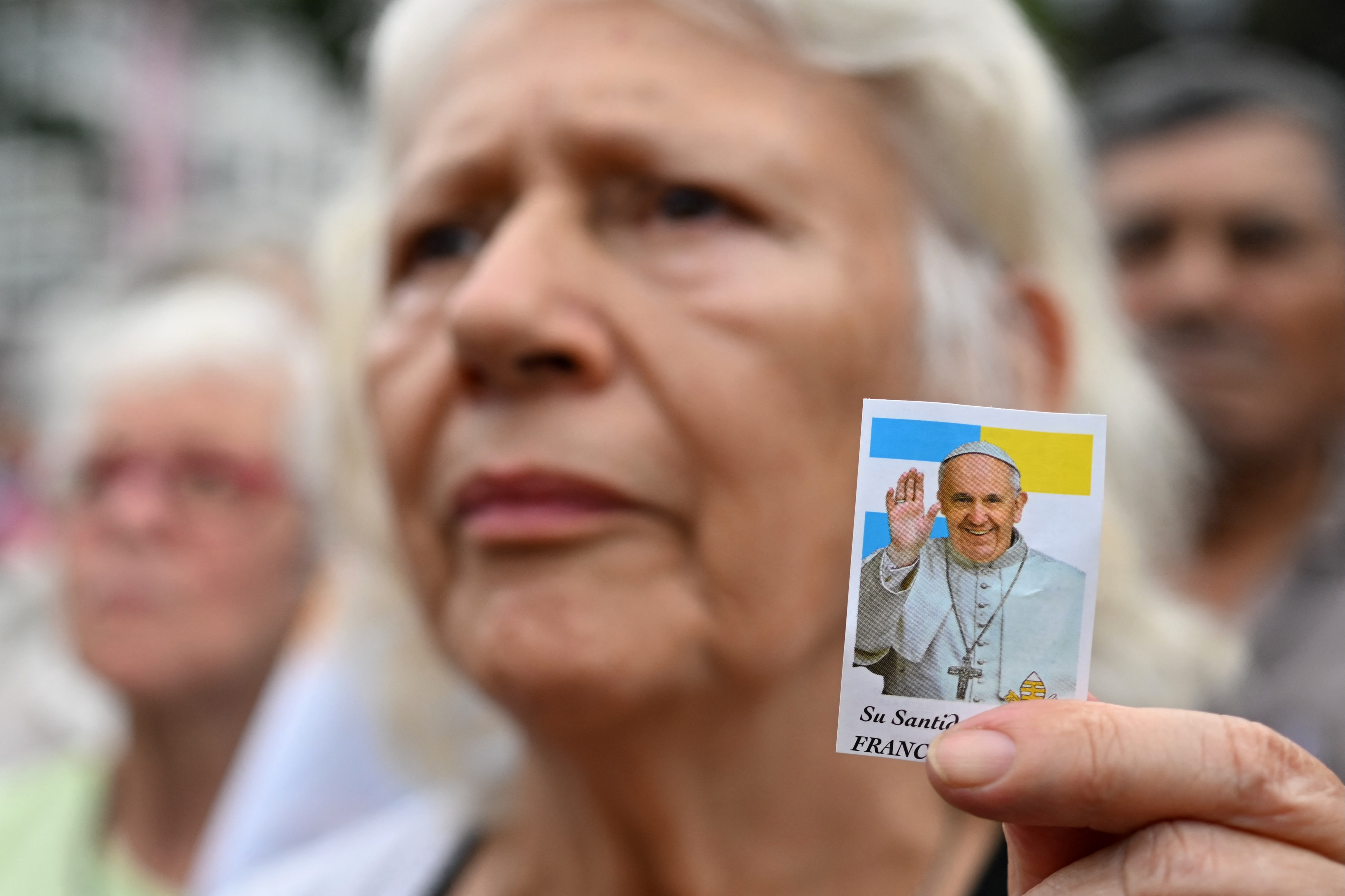A woman holds a portrait of Pope Francis as she attends a mass for his healing in Constitution Square, the place where, when he was archbishop of Buenos Aires he gave annual masses to denounce exclusion and human trafficking in Buenos Aires, on February 24, 2025.