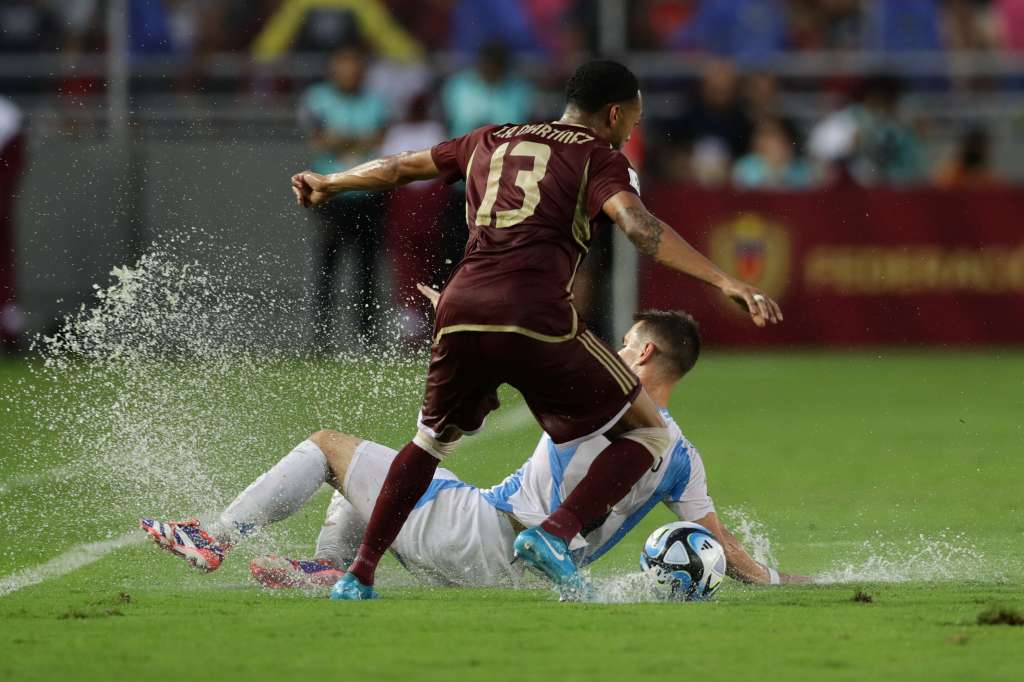 AMDEP8574. MATURÍN (VENEZUELA), 10/10/2024.- José Martínez (i) de Venezuela disputa un balón con Giovani Lo Celso de Argentina este jueves, en un partido de las eliminatorias sudamericanas para el Mundial de 2026 entre Venezuela y Argentina en el estadio Monumental de Maturín (Venezuela). EFE/ Ronald Peña R.